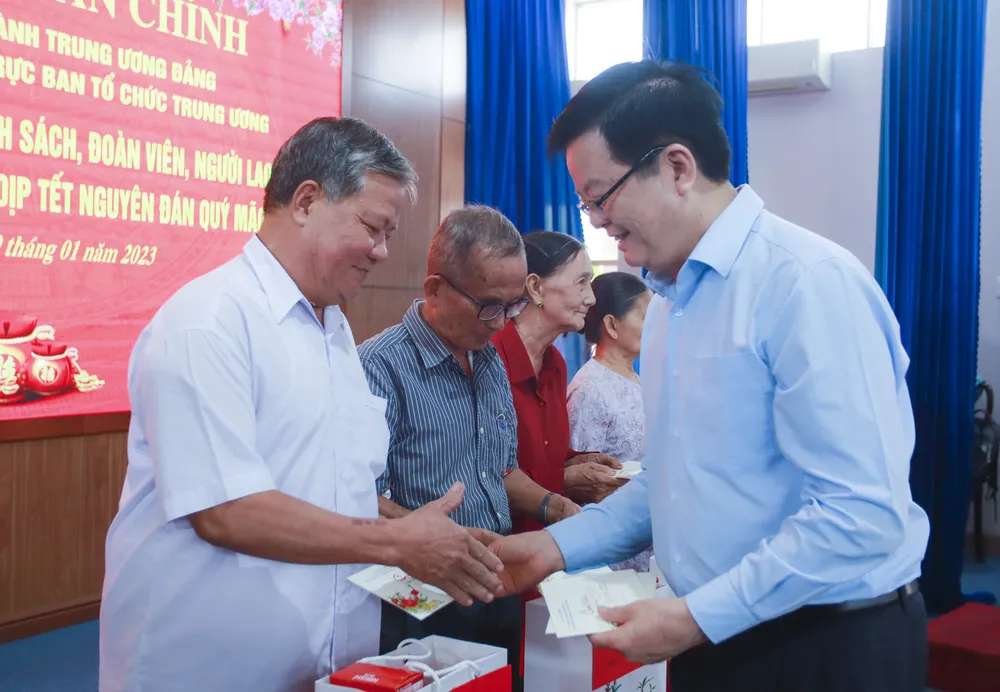 Phó Trưởng ban thường trực Ban Tổ chức Trung ương Mai Văn Chính trao quà cho gia đình chính sách. Ảnh: HUỲNH DU