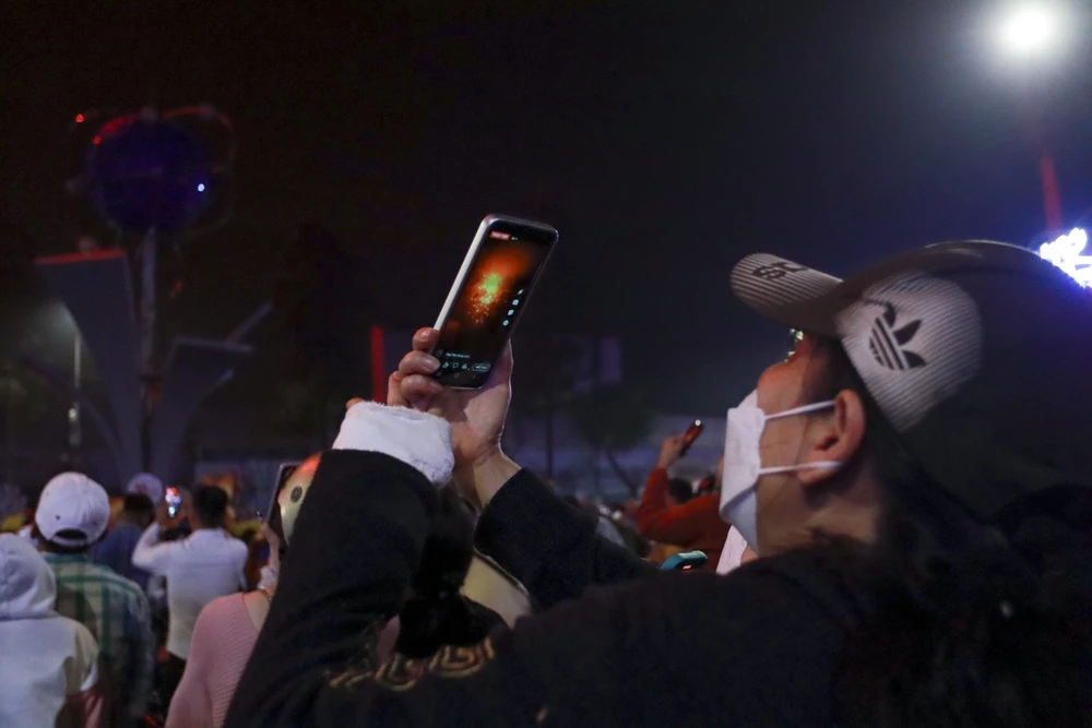 Hàng ngàn người dân vỗ tay tán thưởng, dùng điện thoại ghi lại những khoảnh khắc pháo hoa rực rỡ chào đón năm mới xuân Quý Mão trên bầu trời TP. Tân An. Ảnh: HUỲNH DU