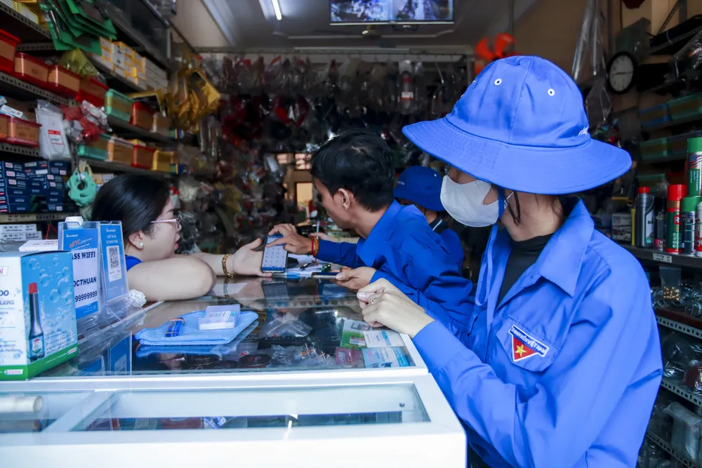 Đoàn viên, thanh niên hướng dẫn, tuyên truyền người dân cách cài đặt tham gia chuyển đổi số, thủ tục hành chính trực tuyến. Ảnh: HUỲNH DU