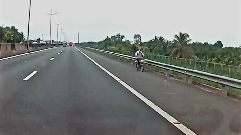 Người đàn ông chạy xe đạp điện ngược chiều trên cao tốc. Ảnh: KIM HƯỚNG