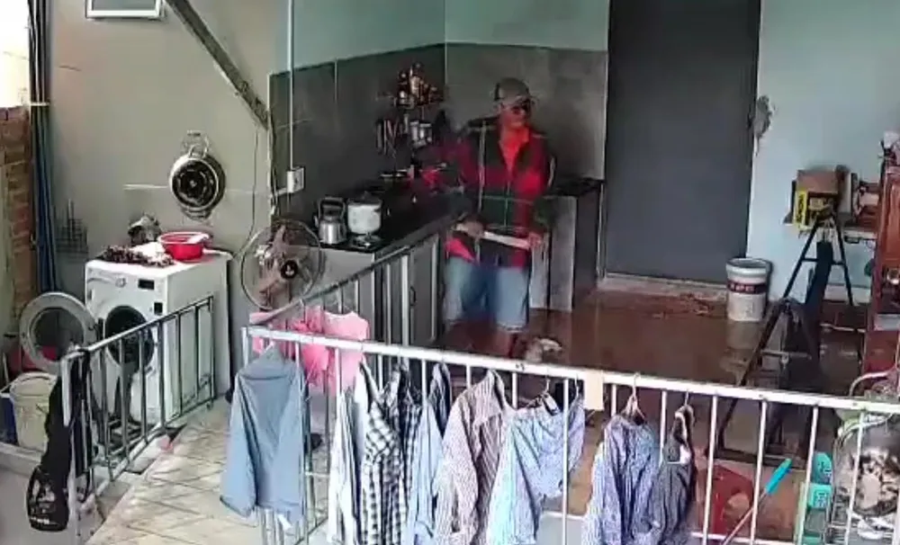 Camera ghi lại cảnh người đàn ông đi vào nhà la lối lớn tiếng và dùng dao đập cửa nhà bà Dưa. Ảnh: Cắt từ clip