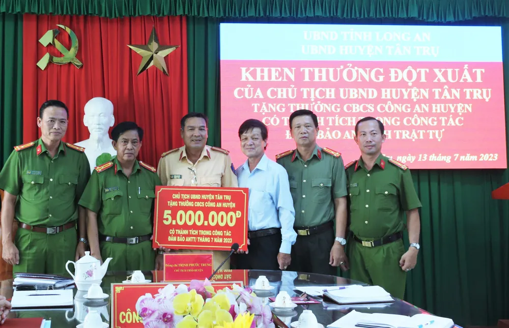 Chủ tịch UBND huyện Tân Trụ Trịnh Phước Trung tặng thưởng đột xuất cho cán bộ, chiến sĩ Công an huyện vì có thành tích trong công tác bảo đảm an ninh, trật tự. Ảnh: THANH MỸ