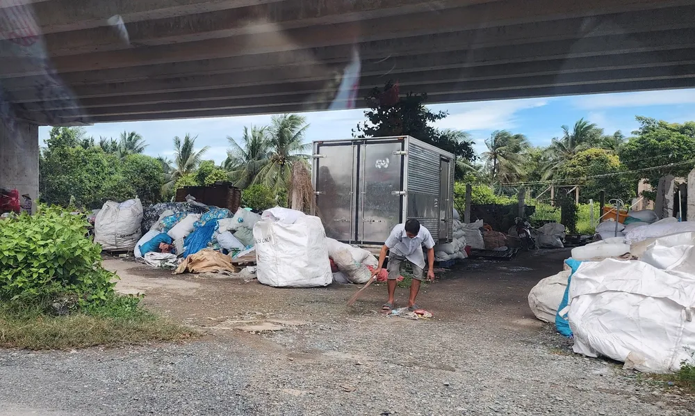 Hàng rào cao tốc bị cắt bỏ để tập kết phế liệu phía dưới gầm đường cao tốc. Ảnh: ĐT