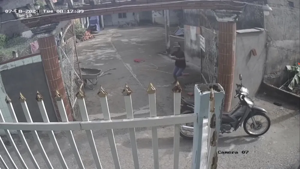 Camera ghi lại cảnh Tiến nhảy lò cò vào trộm máy hàn điện rồi ra xe tẩu thoát. Ảnh cắt từ clip