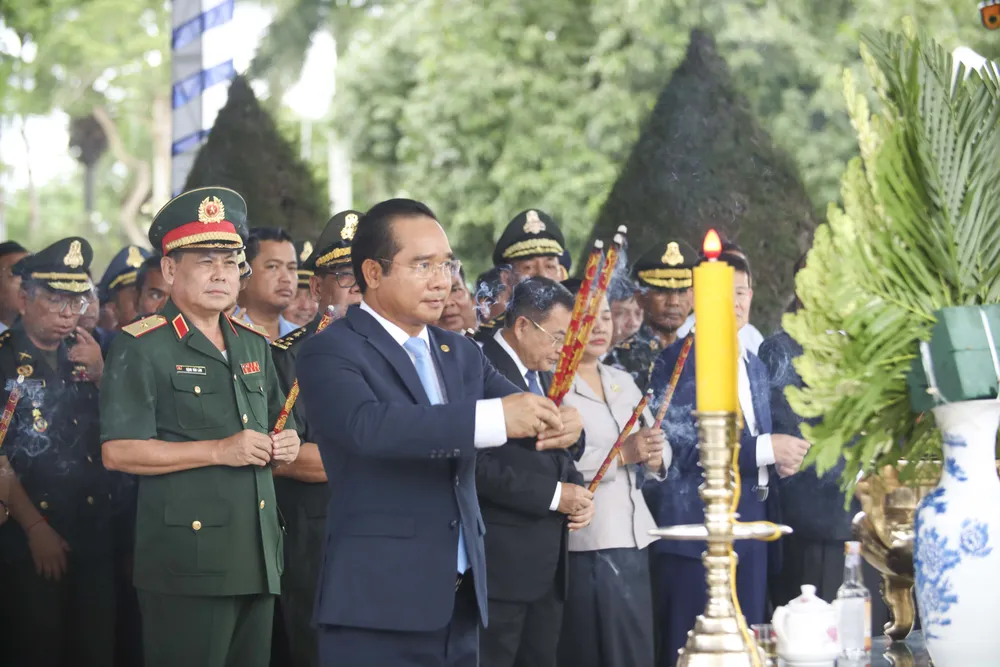 Đại biểu dâng hương kính viếng hương hồn các anh hùng liệt sĩ tại Nghĩa trang liệt sĩ huyện Vĩnh Hưng - Tân Hưng. Ảnh: HUỲNH DU