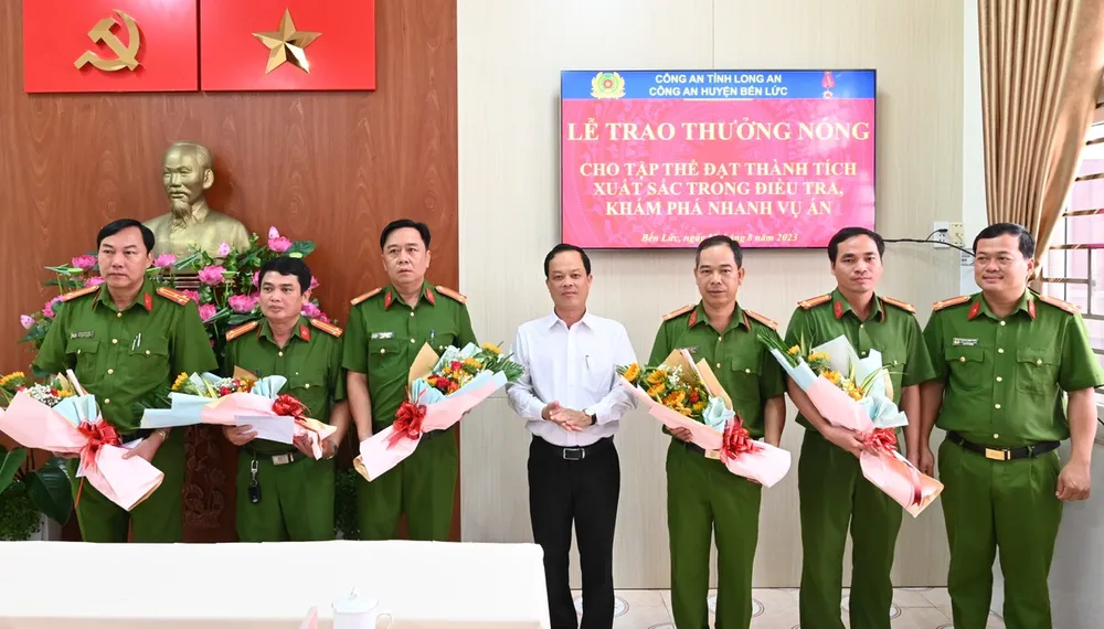 Chủ tịch UBND huyện Bến Lức đã đến tặng hoa khen thưởng các tập thể đã có thành tích xuất sắc khám phá nhanh vụ trộm. Ảnh: KIM PHƯỢNG