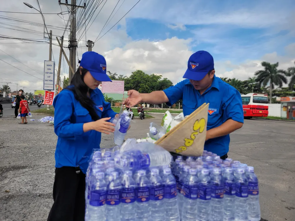 Nhóm tình nguyện chọn nơi đất trống ven Quốc lộ làm nơi phát nước miễn phí. Ảnh: HD