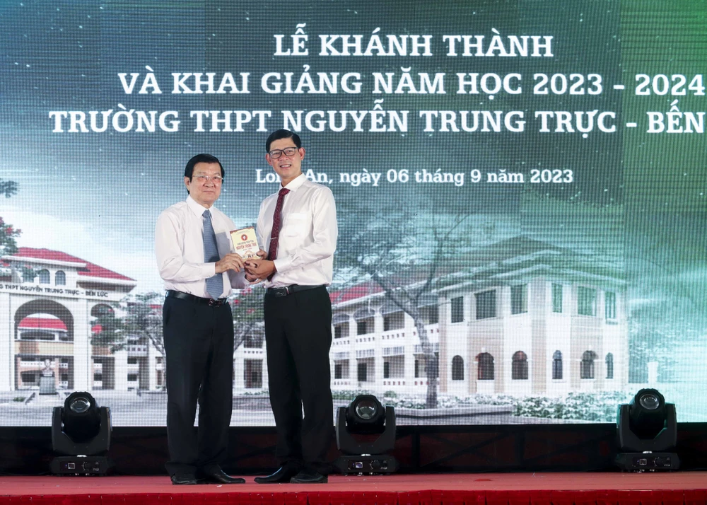 Nguyên Chủ tịch nước trao tặng quyển sách Anh hùng dân tộc Nguyễn Trung Trực cho hiệu trưởng trường THPT Nguyễn Trung Trực. Ảnh: HUỲNH DU