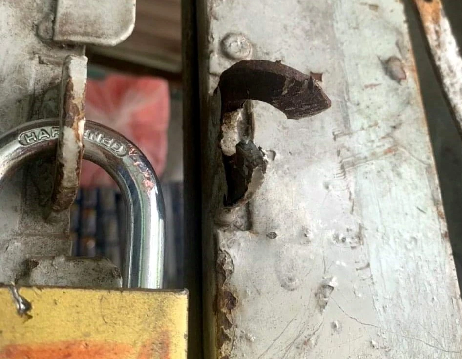 Ổ khóa tại tiệm tạp hóa đã bị Trí cắt khóa để đột nhập vào bên trong. Ảnh: CA