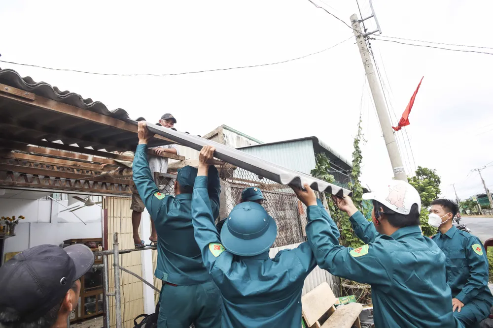 Lực lượng dân quân xã Bình Qưới hỗ trợ giúp dân lợp lại mái nhà. Ảnh: HUỲNH DU Lực lượng dân quân xã Bình Qưới hỗ trợ giúp dân lợp lại mái nhà. Ảnh: HUỲNH DU