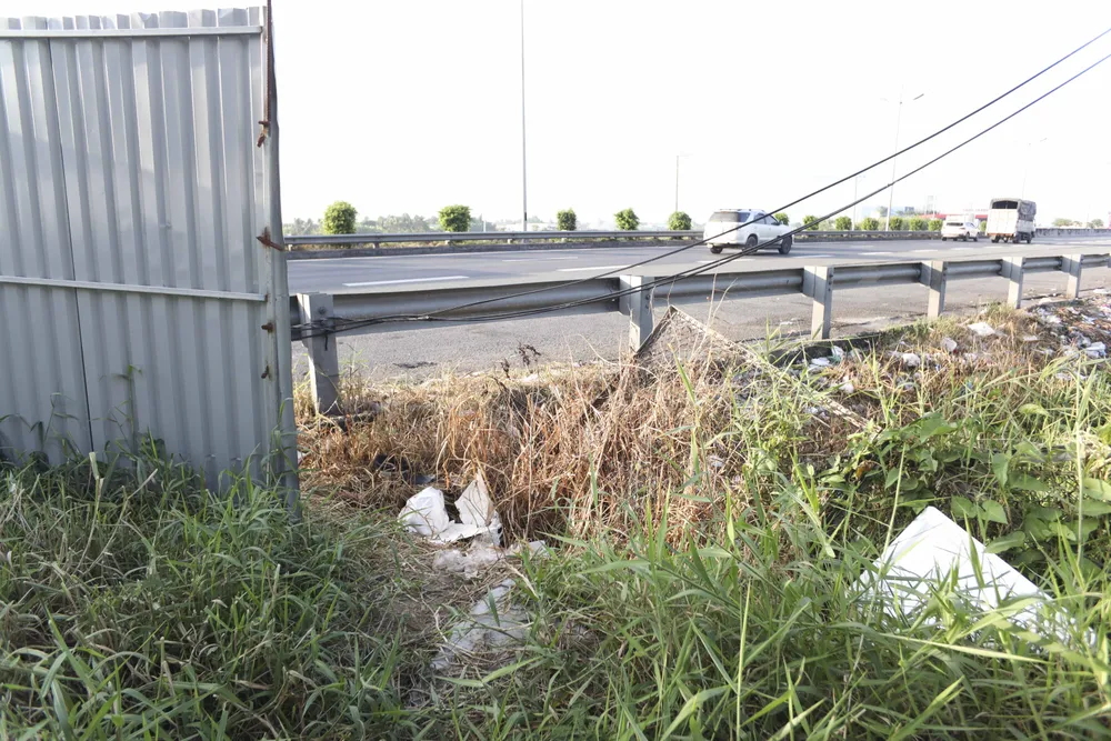 Khu vực phía dưới cầu vượt số 3, gần trạm dừng chân cao tốc, hàng rào bị cắt phá rất tạo lối lên xuống và cũng là nơi ô nhiễm nhất trên đoạn này. Ảnh: HUỲNH DU