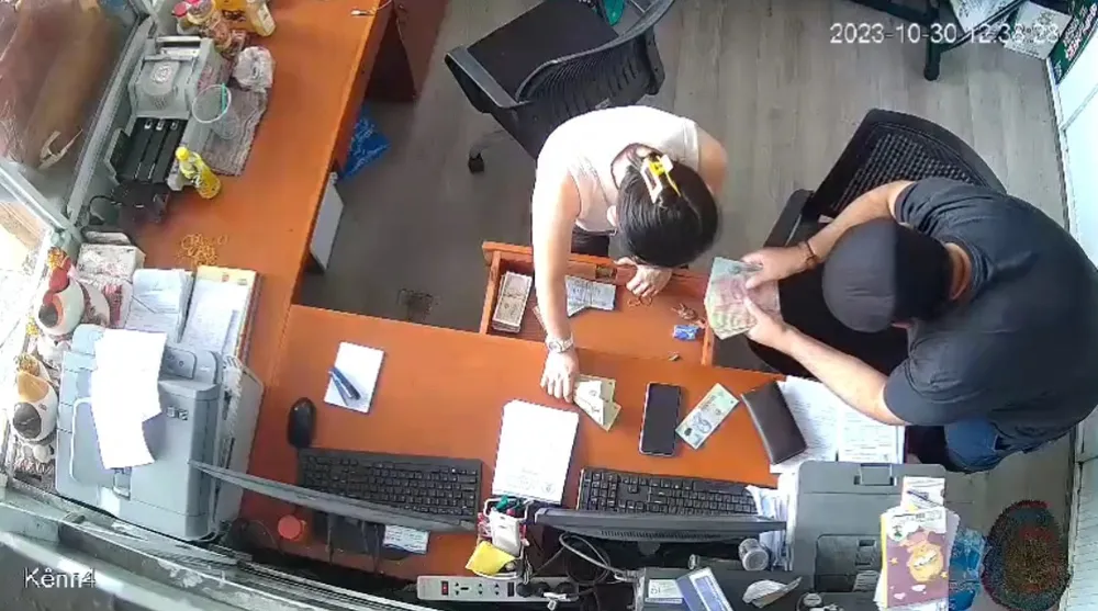 Chị kế toán đưa tiền cho một người nước ngoài đếm, đổi tiền. Ảnh: Cắt từ clip Screenshot_20231031_124540_Zalo.jpg
