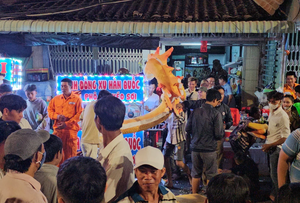 Mặc khác, một số người đến sau nhanh chóng tìm kiếm trong đống đồ cúng những món có thể mang về nhà như bánh kẹo, hoa, vàng mã, những phần còn lại của linh vật rồng biểu tưởng của năm. Lễ hội Làm Chay 12.jpg