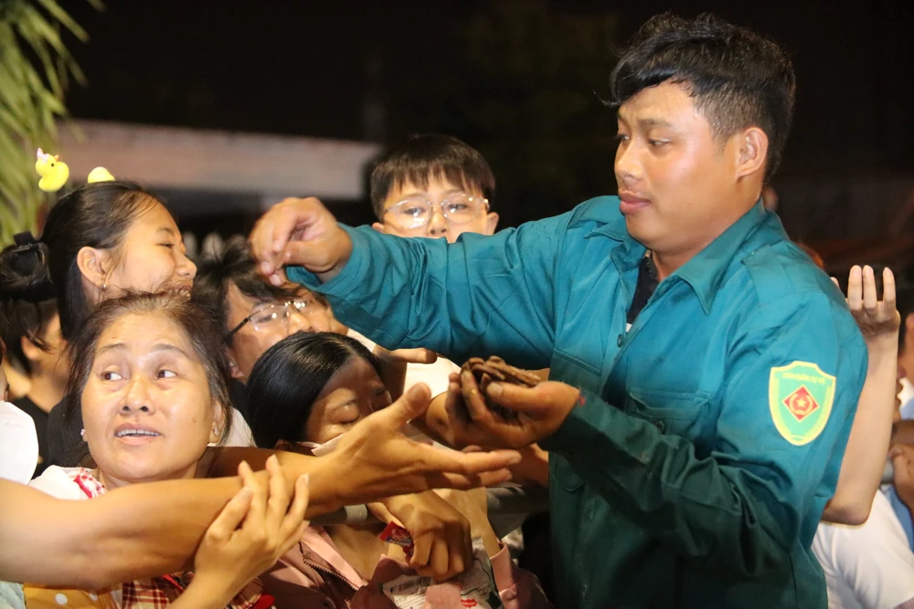 Dân quân địa phương hỗ trợ giúp phát lộc cho người dân. Lễ hội Làm Chay (7).JPG