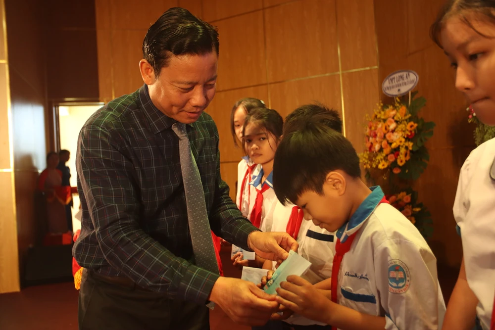 Ông Phạm Tấn Hòa, Phó Chủ tịch UBND tỉnh Long An trao tặng quà cho các em học sinh khó khăn vươn lên trong học tập tại lễ phát động. Ảnh: HD Ngày Sách và Văn hóa đọc Việt Nam (1).JPG