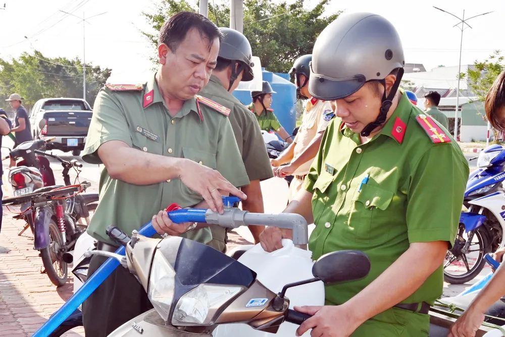 Công an huyện đã giúp người dân bằng nhiều việc làm như bơm nước, phát nước miễn phí, vận chuyển nước đến vùng khó khăn. Ảnh: HD công an cứu khát cho người dân (3).jpg
