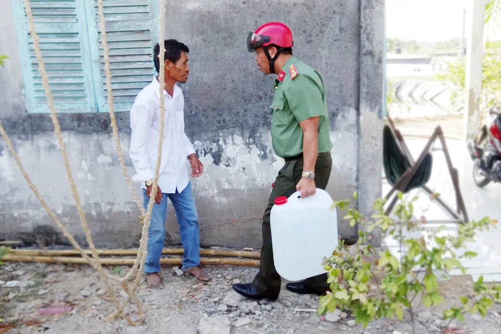 Lực lượng Công an huyện Cần Giuộc không ngại vất vả giúp dân có những can nước để sử dụng. Ảnh: HD công an cứu khát cho người dân (4).jpg