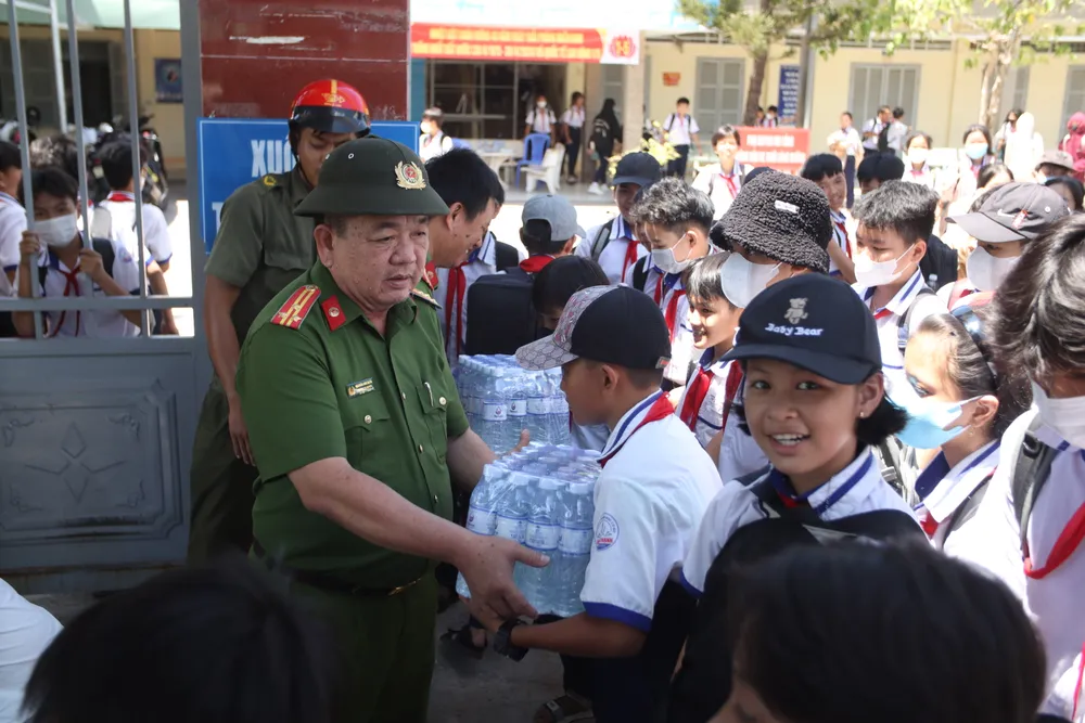 Thượng tá Nguyễn Văn Quân tham gia cùng lực lượng công an xã Đông Thạnh hỗ trợ phát nước cho các em học sinh. Ảnh: HD công an cứu khát cho người dân (6).JPG