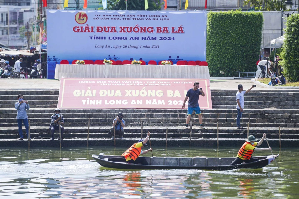 Rất đông người dân hai bên bờ sông Bảo Định đến cổ vũ và dùng máy ảnh, điện thoại ghi lại khoảnh khắc tại giải đua xuồng ba lá. đua xuồng ba lá_8.JPG
