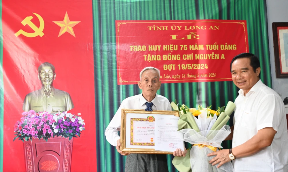 Ông Nguyễn Văn Được, Bí thư Tỉnh ủy Long An trao huy hiệu 75 năm tuổi đảng cho đảng viên Nguyễn A. Ảnh: LH trao huy hiệu 75 năm tuổi Đảng.jpg
