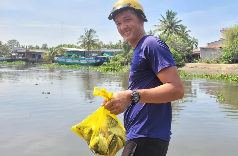 Anh Lê Minh Thiện bắt gần 2kg cá các loại sau 1 giờ tham gia bắt cá tại khu vực cống Bắc Đông. Ảnh: HD mở cống ngăn mặn 1.jpg