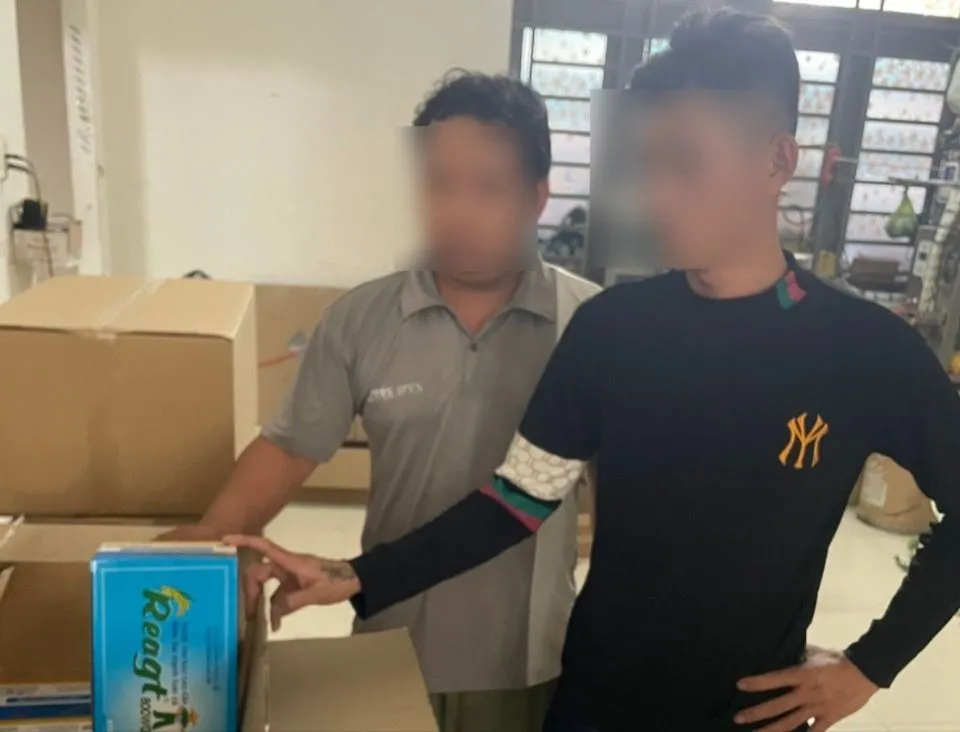 Hai công nhân tại căn nhà có dấu hiệu sản xuất thuốc bảo vệ thực vật giả. Ảnh:CA Thuốc bảo vệ thực vật giả..jpg