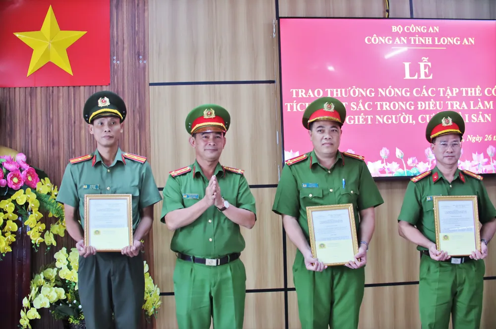 Đại tá Phạm Thanh Tâm, Phó Giám đốc Công an tỉnh trao thưởng cho các tập thể xuất sắc phá nhanh vụ án. Ảnh: HUỲNH DU người lái xe ôm 4.JPG