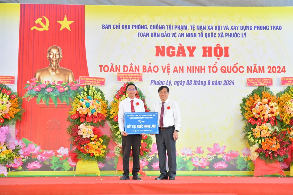 Ông Phan Xuân Thủy - Phó Trưởng Ban Tuyên giáo Trung ương tặng quà cho xã Phước Lý. Ảnh: HD Long An phát huy tốt phong trào Toàn dân bảo vệ an ninh Tổ quốc