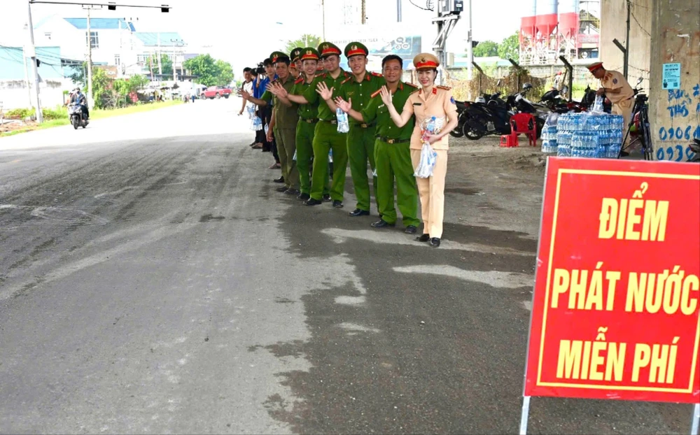 Lực lượng Công an huyện Bến Lức tổ chức điểm phát nước miễn phí cho người dân trên tuyến quốc lộ 1 và Tỉnh lộ 830C. Ảnh: VH Nghỉ lễ Quốc khánh 2-9.jpg