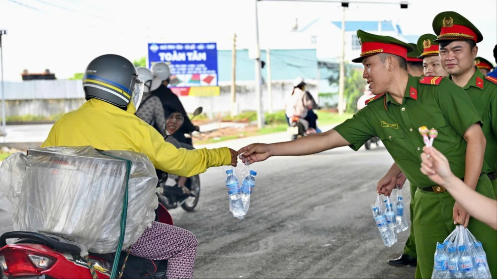 Cán bộ chiến sỹ công an phát 1.000 chai nước suối cho người dân về miền Tây nghỉ lễ Quốc khánh 2-9. Ảnh: VH Nghỉ lễ Quốc khánh 2-9.jpg