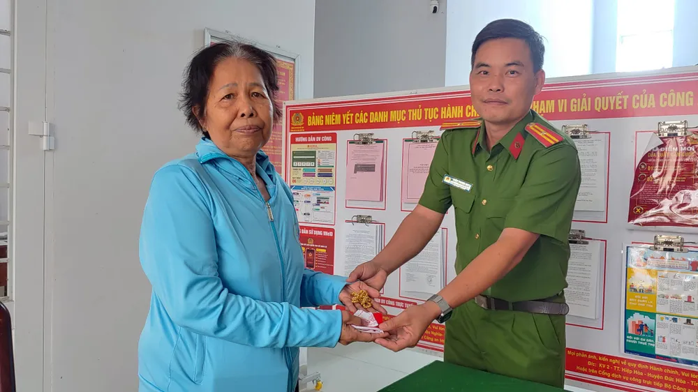 Bà Cao nhận lại sợi dây chuyền làm rời từ Công an thị trấn Hiệp Hòa. Ảnh: KT làm rơi vàng (3).jpg