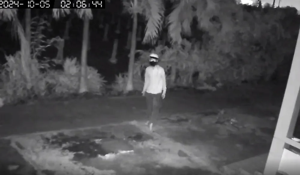 Một trong ba thanh niên quan sát nhà của chị N. trước khi bẻ khóa đột nhập. Ảnh: Cắt từ clip