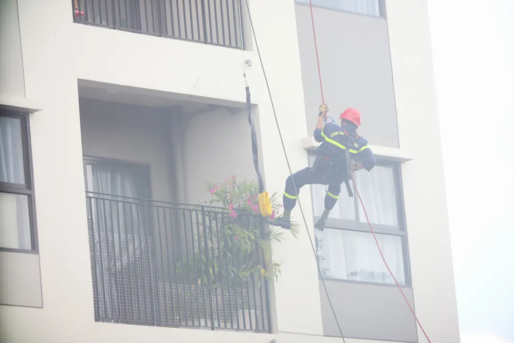Lực lượng PCCC tìm cách tiếp cận hỗ trợ nạn nhân tại các căn hộ của tòa nhà. Ảnh: HD diễn tập PCCC (14).JPG