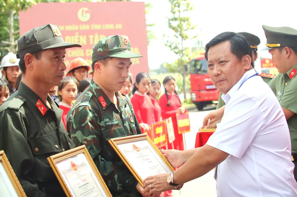 Ông Huỳnh Văn Sơn, Phó Chủ tịch UBND tỉnh Long An, trao tặng bằng khen cho các tập thể và cá nhân có thành tích xuất sắc tham gia diễn tập. Ảnh: HD diễn tập PCCC 25.JPG