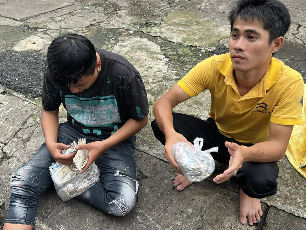 Hai thanh niên kiểm kê lại số tiền. Anh Huy (18 tuổi, mặc áo đen, hiện đang lao động tự do tại quận 5) chê năm nay số tiền giật ít hơn năm trước. Anh cho biết: "Đi giựt tiền với anh em rất vui, nhưng năm nay tiền ít quá, chắc do tình hình kinh doanh khó khăn nên các hộ dân đã giảm lại".