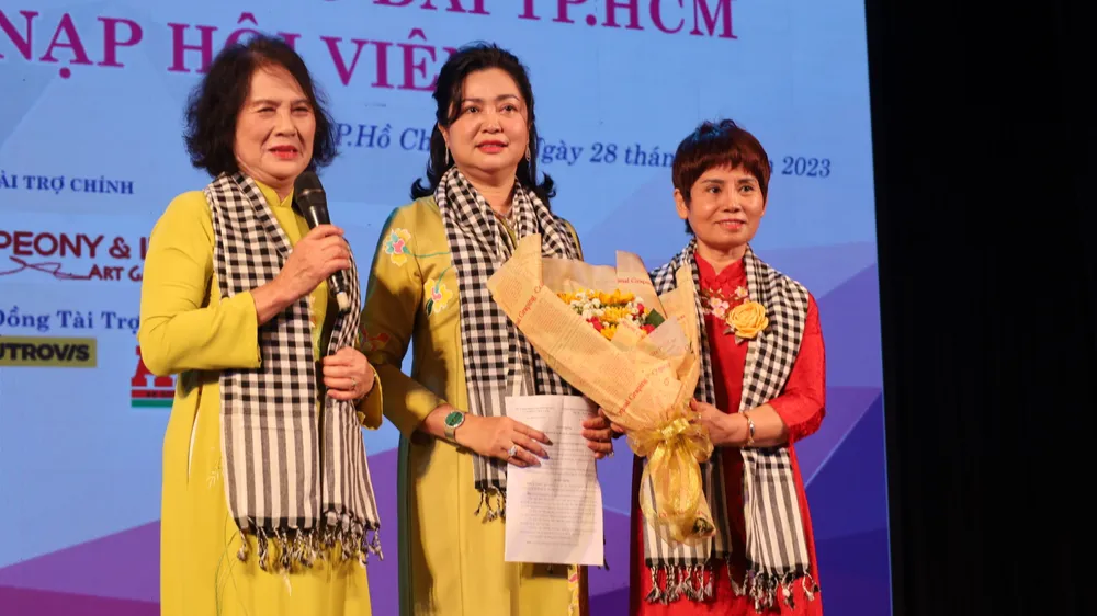 Bà Phùng Thị Thu Thuỷ (đứng giữa), Chủ nhiệm CLB di sản áo dài TP.HCM nhận hoa chúc mừng nhân ngày ra mắt CLB. Áo dài-1