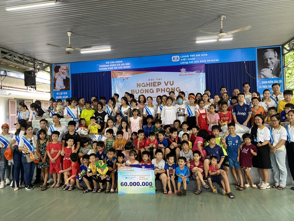 Lãnh đạo quận Gò Vấp và đại diện Sở Du lịch cùng trao những phần quà cho làng trẻ SOS.