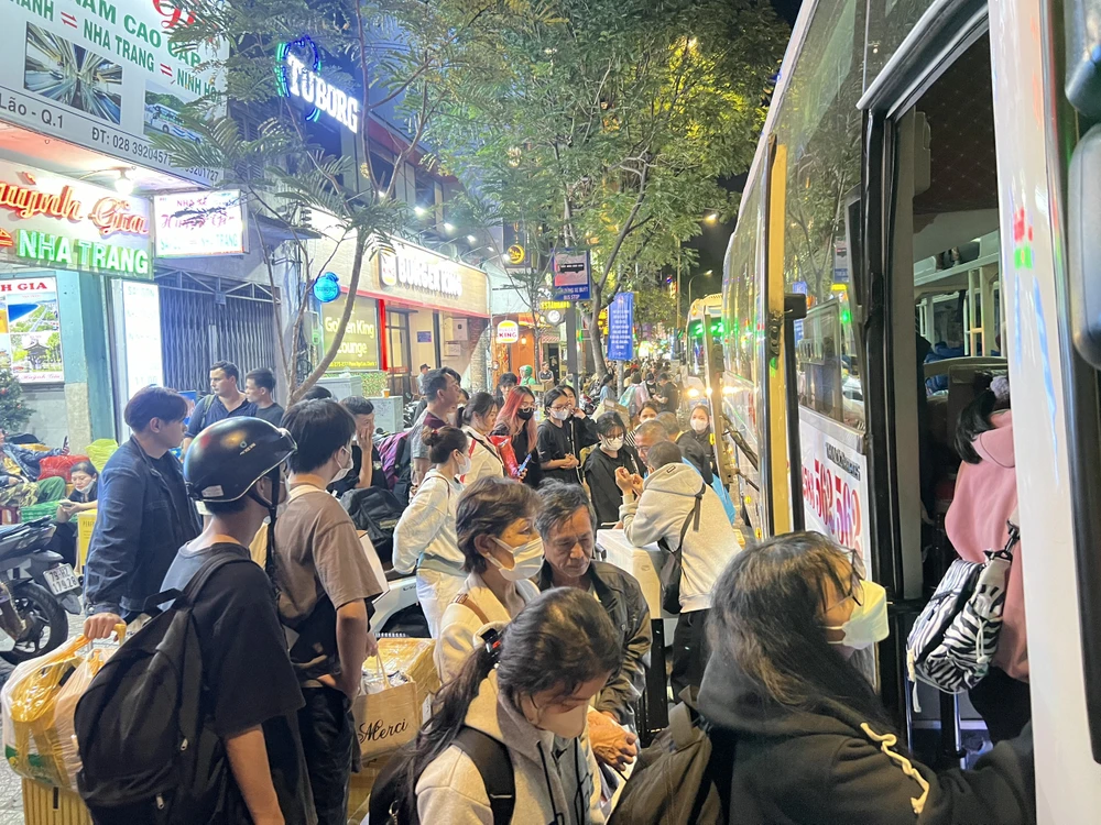 Hành khách lỉnh kỉnh đồ đạc, xếp hàng dài chờ lên xe. Ảnh: HOÀNG HIẾU. ve-que-nghi-tet10.jpg