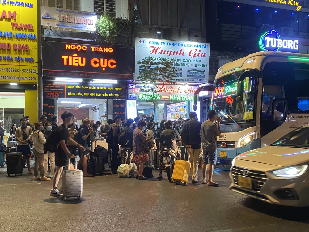 Tại một nhà xe trên đường Phạm Ngũ Lão, hành khách xếp hàng lên xe. Ảnh: HOÀNG HIẾU. ve-que-nghi-tet6.jpg