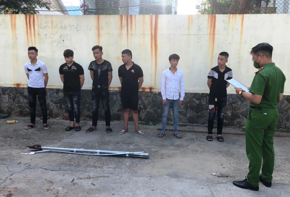 Công an tống đạt quyết định khởi tố những bị can trong vụ án. Ảnh: HẢI HIẾU