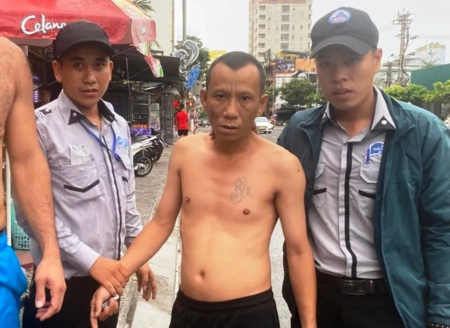 Hai nhân viên Đội Quản lý trật tự thuộc Ban quản lý Bán đảo Sơn Trà kịp thời bắt giữ nghi phạm Nguyễn Văn Đức (giữa). Ảnh: H.H Hai nhân viên Đội Quản lý trật tự thuộc Ban quản lý Bán đảo Sơn Trà kịp thời bắt giữ nghi phạm Nguyễn Văn Đức (giữa). Ảnh: H.H