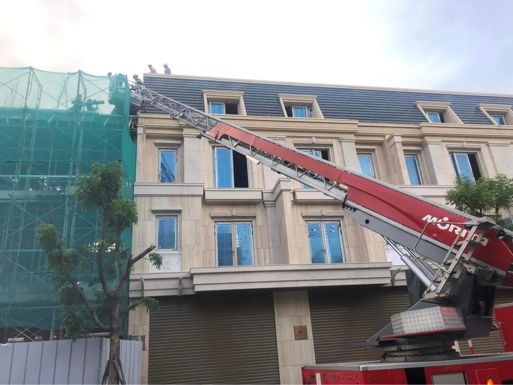 Lực lượng chức năng dùng xe thang giải cứu người mắc kẹt. Ảnh: NGÔ QUANG