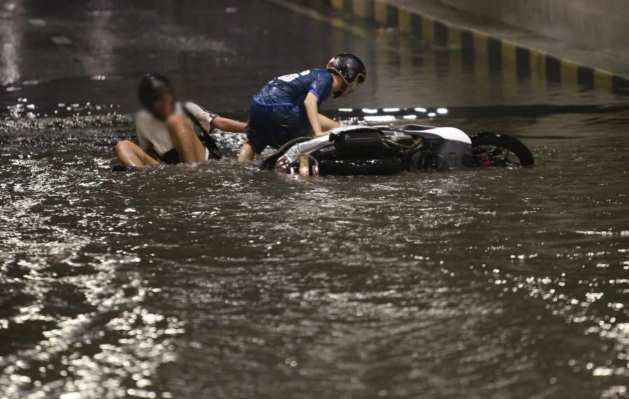 Người đi xe máy trượt ngã tại thời điểm hầm chui ngập nước. Ảnh: H.H