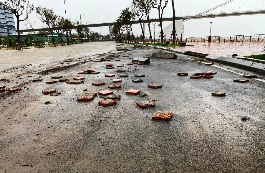 Gạch đá trên vỉa hè bị sóng đánh bong tróc xuống mặt đường. Ảnh: HẢI HIẾU Gạch đá trên vỉa hè bị sóng đánh bong tróc xuống mặt đường. Ảnh: HẢI HIẾU