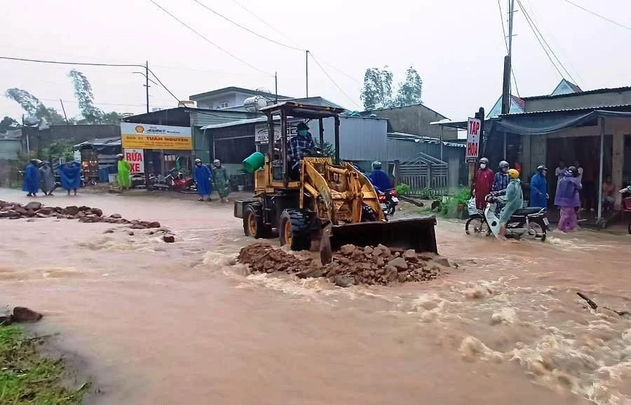 Đất đá cuốn theo dòng nước trôi xuống Quốc lộ 14B. Ảnh: HẢI HIẾU