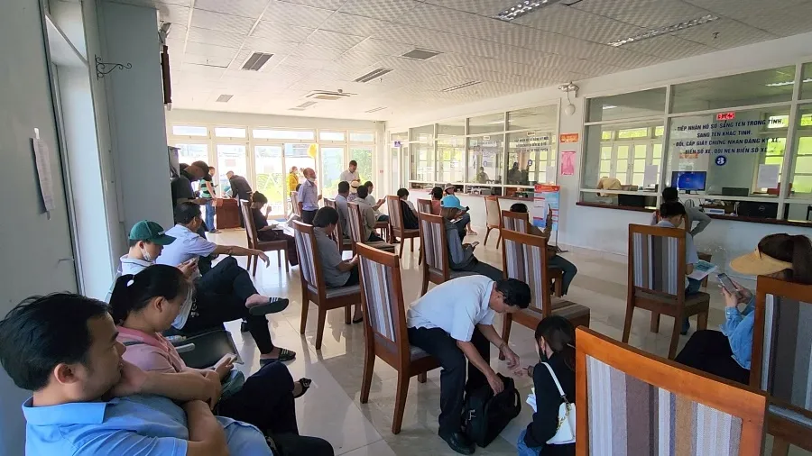 Hàng chục người dân ngồi chờ đợi để được bấm biển số nhưng hệ thống bị lỗi. Ảnh: MINH TRƯỜNG Hàng chục người dân ngồi chờ đợi để được bấm biển số nhưng hệ thống bị lỗi. Ảnh: MINH TRƯỜNG