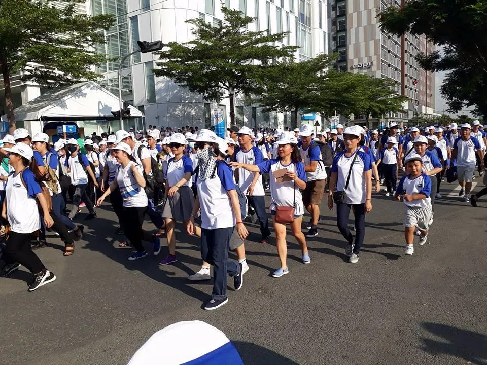 Trẻ con đi bộ cùng người lớn.