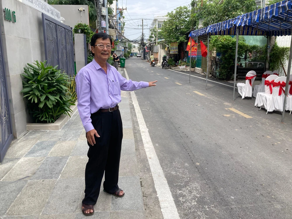Một người dân phấn khởi nhìn con hẻm thay đổi sau 2 năm. Ảnh: HUỲNH THƠ