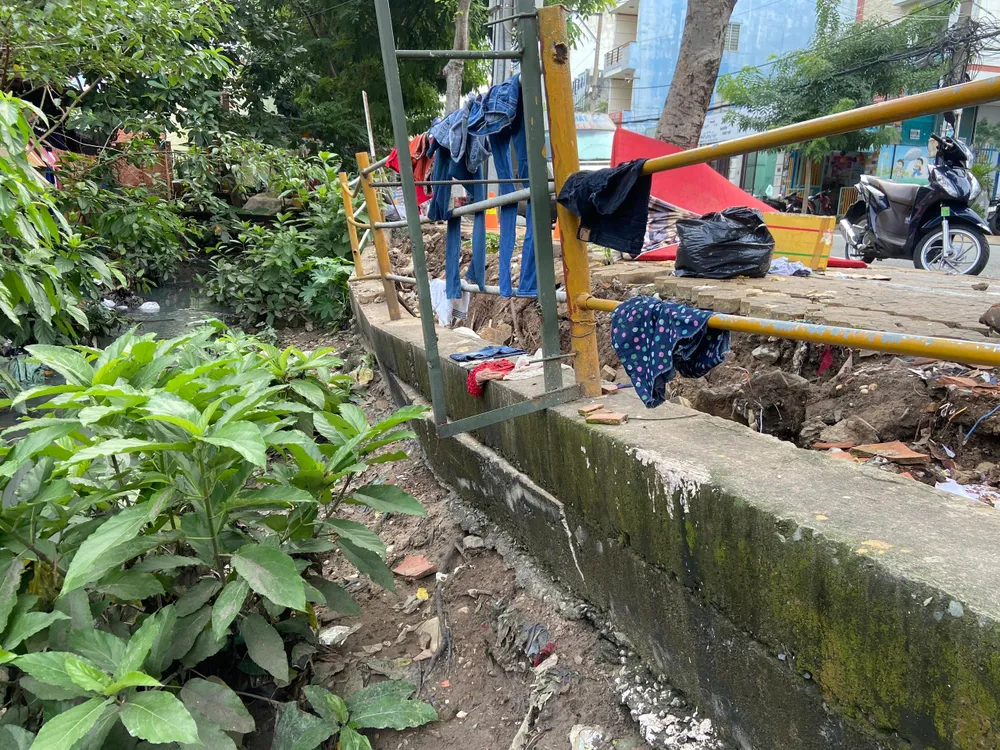 Dù có rào chắn nhưng đất lở khiến rào bị nghiêng về một phía, có nguy cơ sập rào. Ảnh: HUỲNH THƠ Dù có rào chắn nhưng đất lở khiến rào bị nghiêng về một phía, có nguy cơ sập rào. Ảnh: HUỲNH THƠ