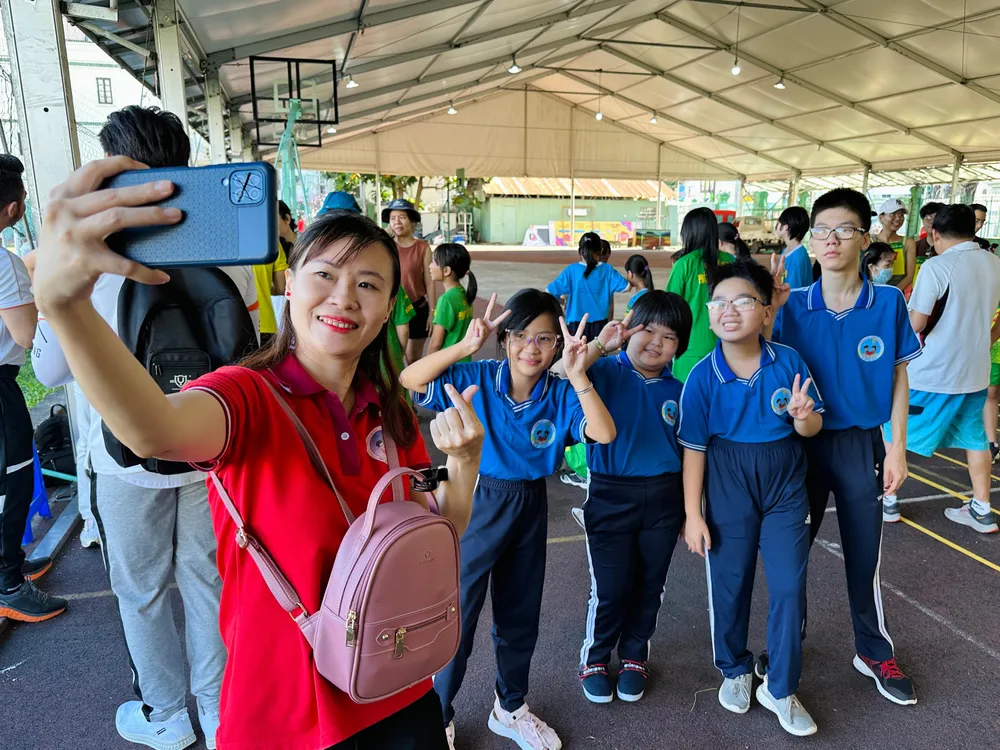 Phần lớn thí sinh dự thi là những trẻ em, người khuyết tật tại TP.HCM. Cô Hồ Thu Vân (áo đỏ), giáo viên trường Hy Vọng quận 6 phấn khởi cùng học sinh của mình chuẩn bị tham dự cuộc thi. Cô cũng là người khiếm thính và khuyết tật ngôn ngữ. Ảnh: HUỲNH THƠ